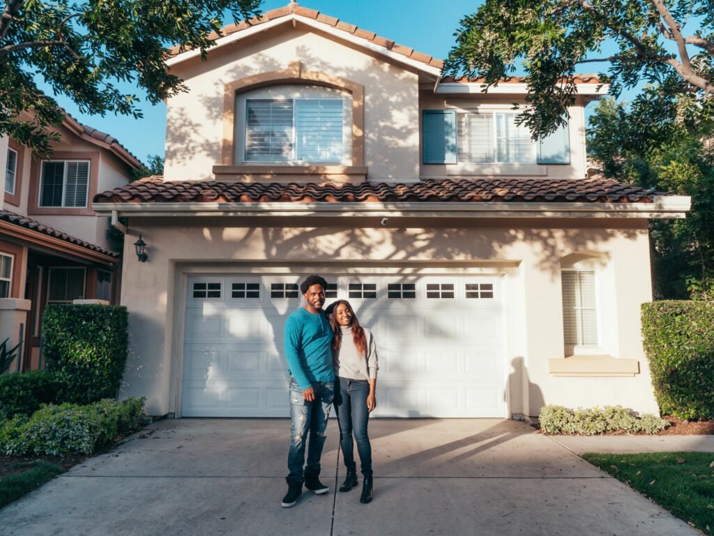pexels-photo-7579046-7579046 A joyous couple stands together in front of their newly purchased house, symbolizing new beginnings.